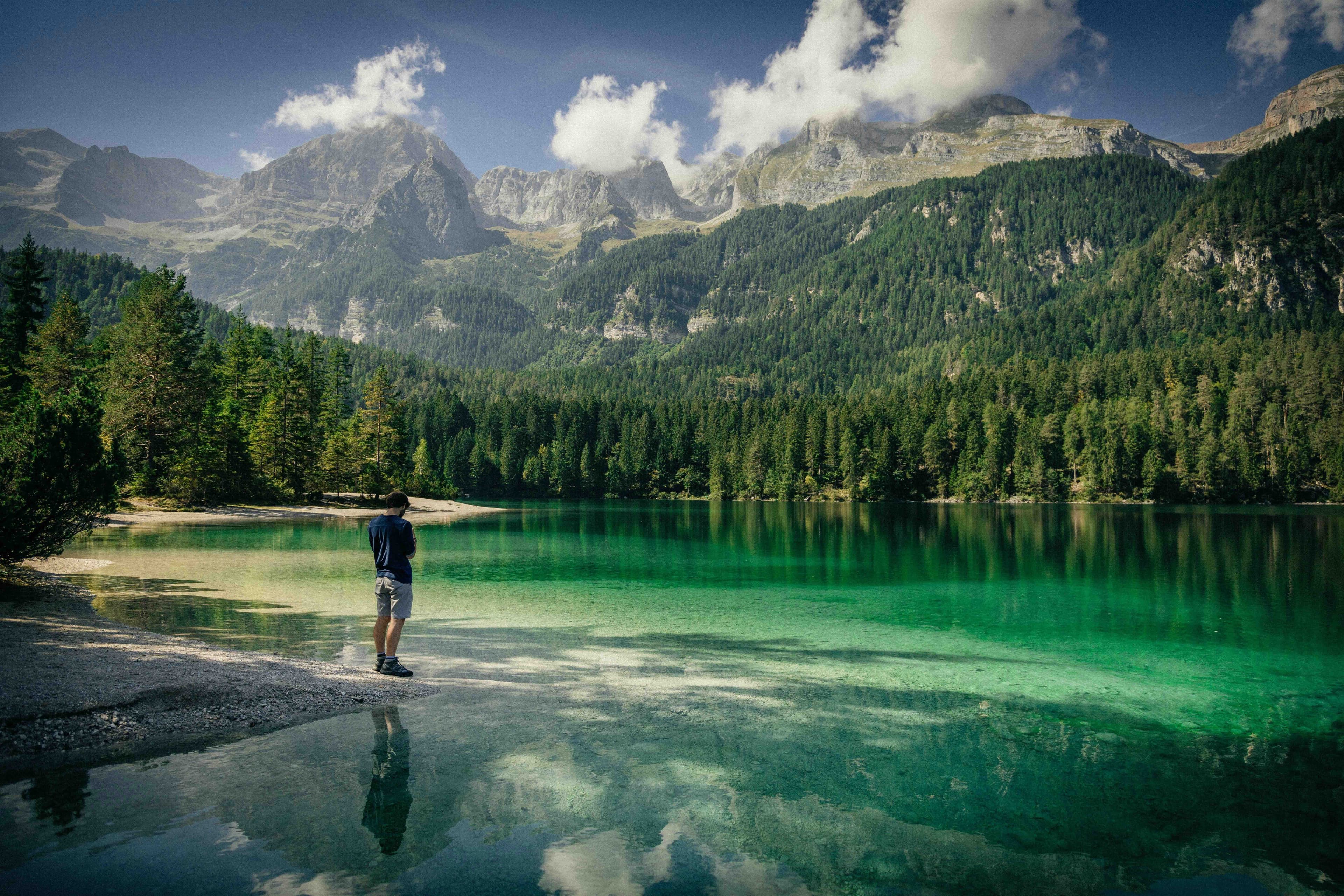 A man in front of lake between mountains